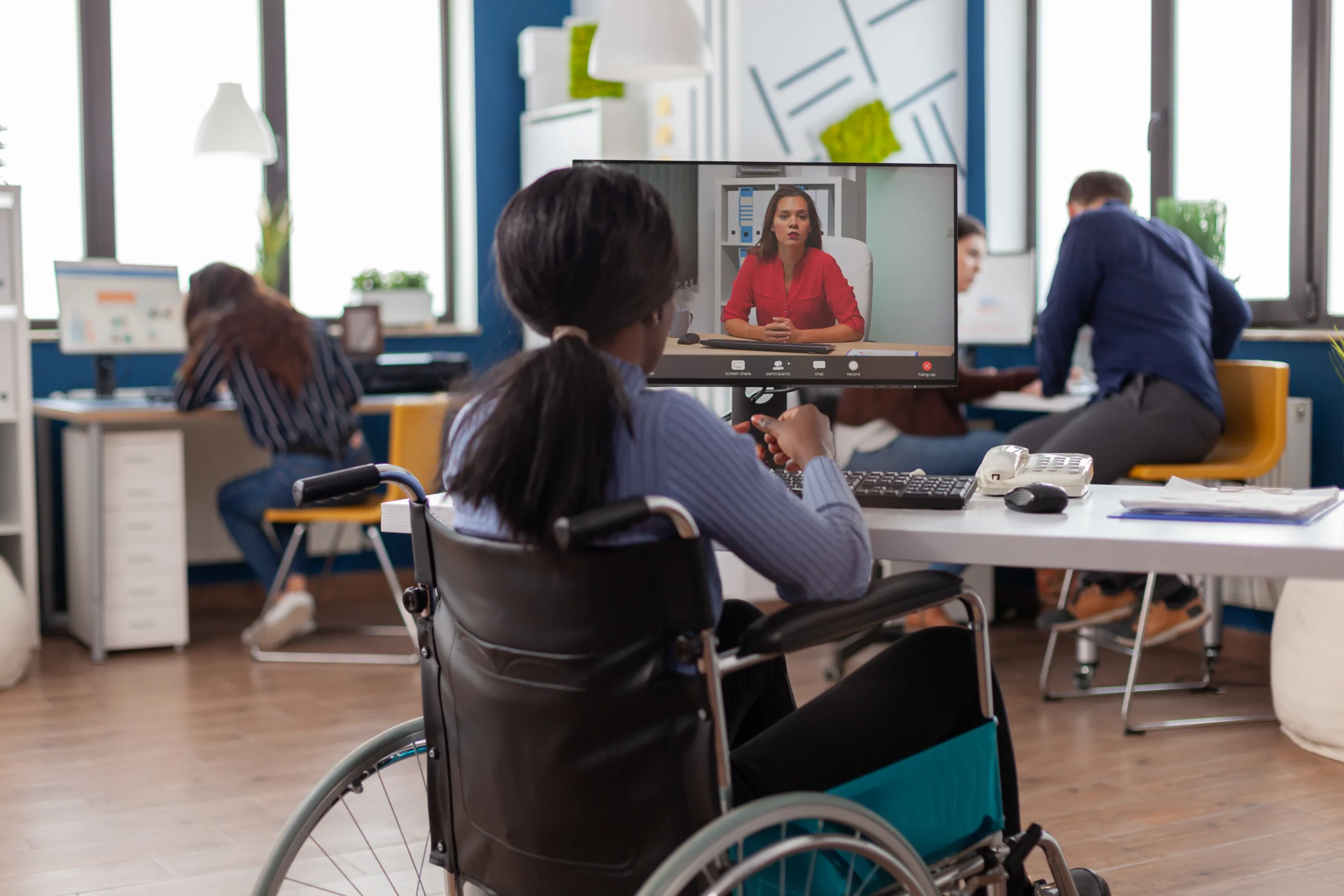 african-disabled-handicapped-businesswoman-sitting-immobilized-wheelchair-talking-with-remote-partner-video-call-from-startup-business-office